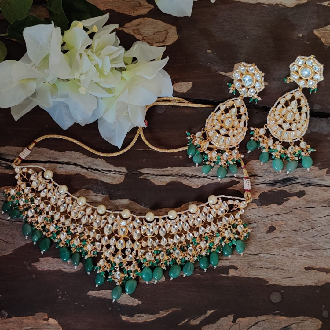 Kundan necklace studded with pearls and emerald stone drops.