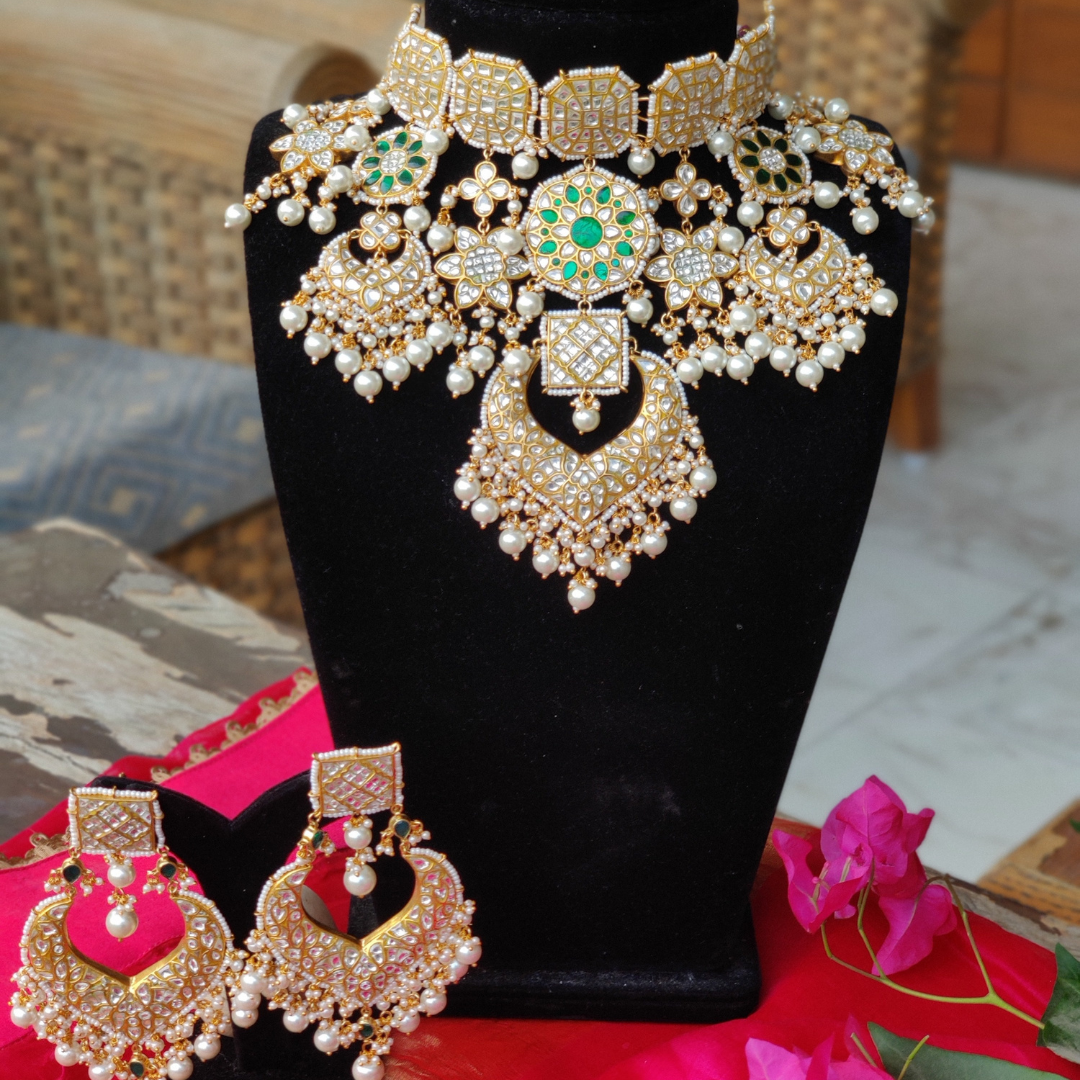 Kundan necklace studded with emerald stones and pearl drops.