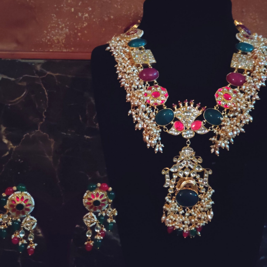 The gold and pearls base with touches of red, green and blue hues