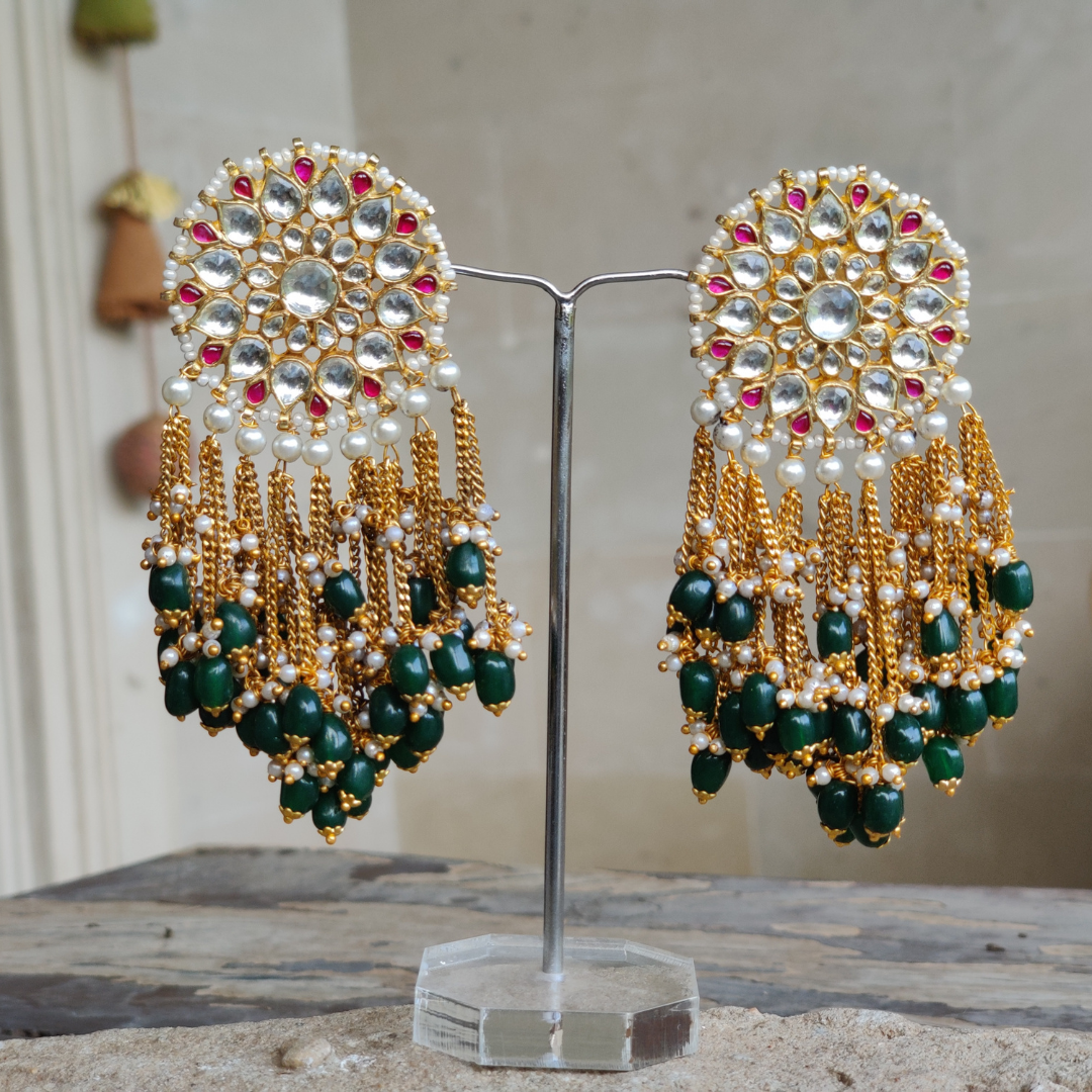 22 K gold plated Kundan earrings studded with white pearls and emerald hangings.