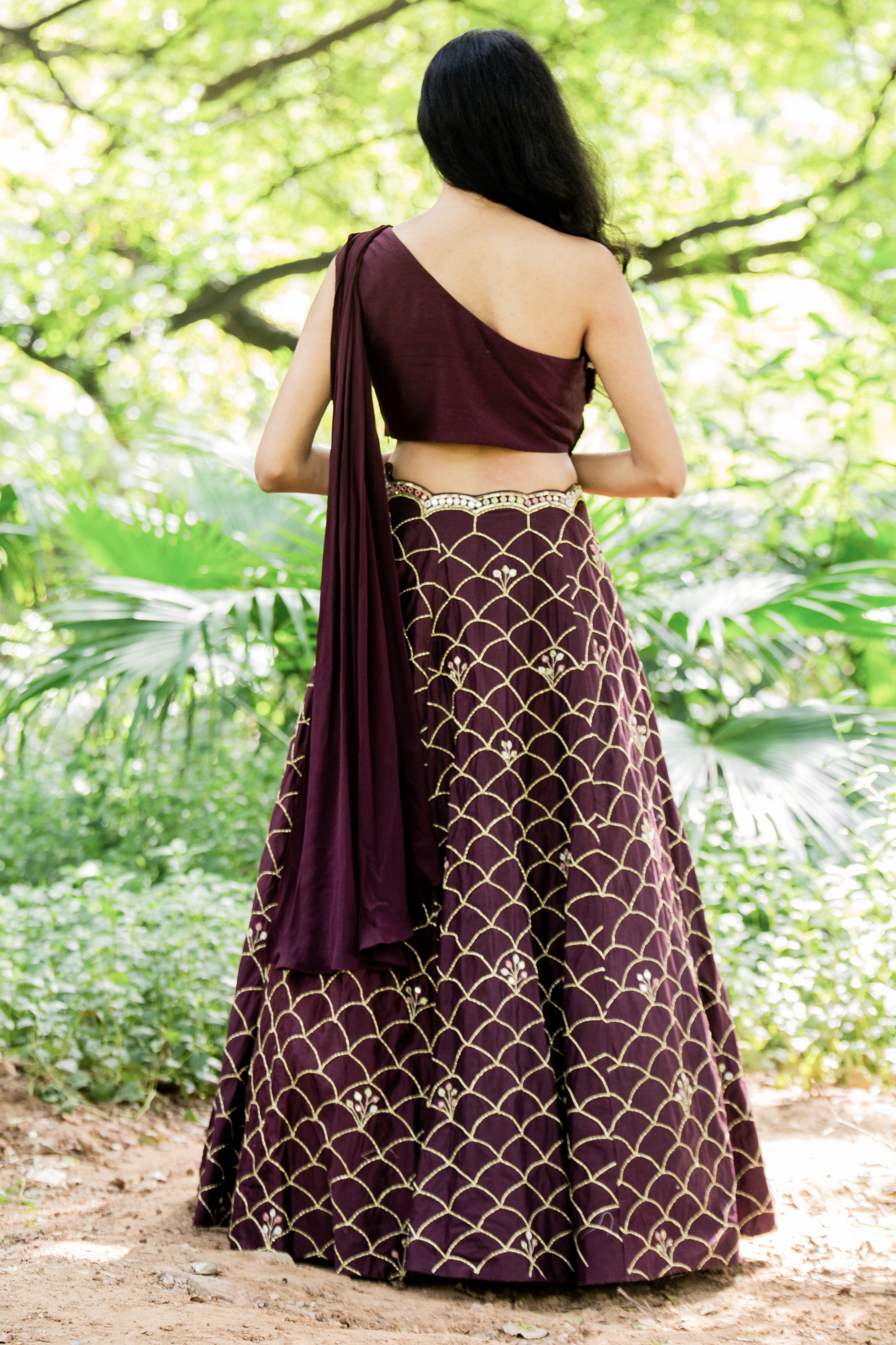 Wine jaal embroidered skirt paired with a one shoulder draped blouse