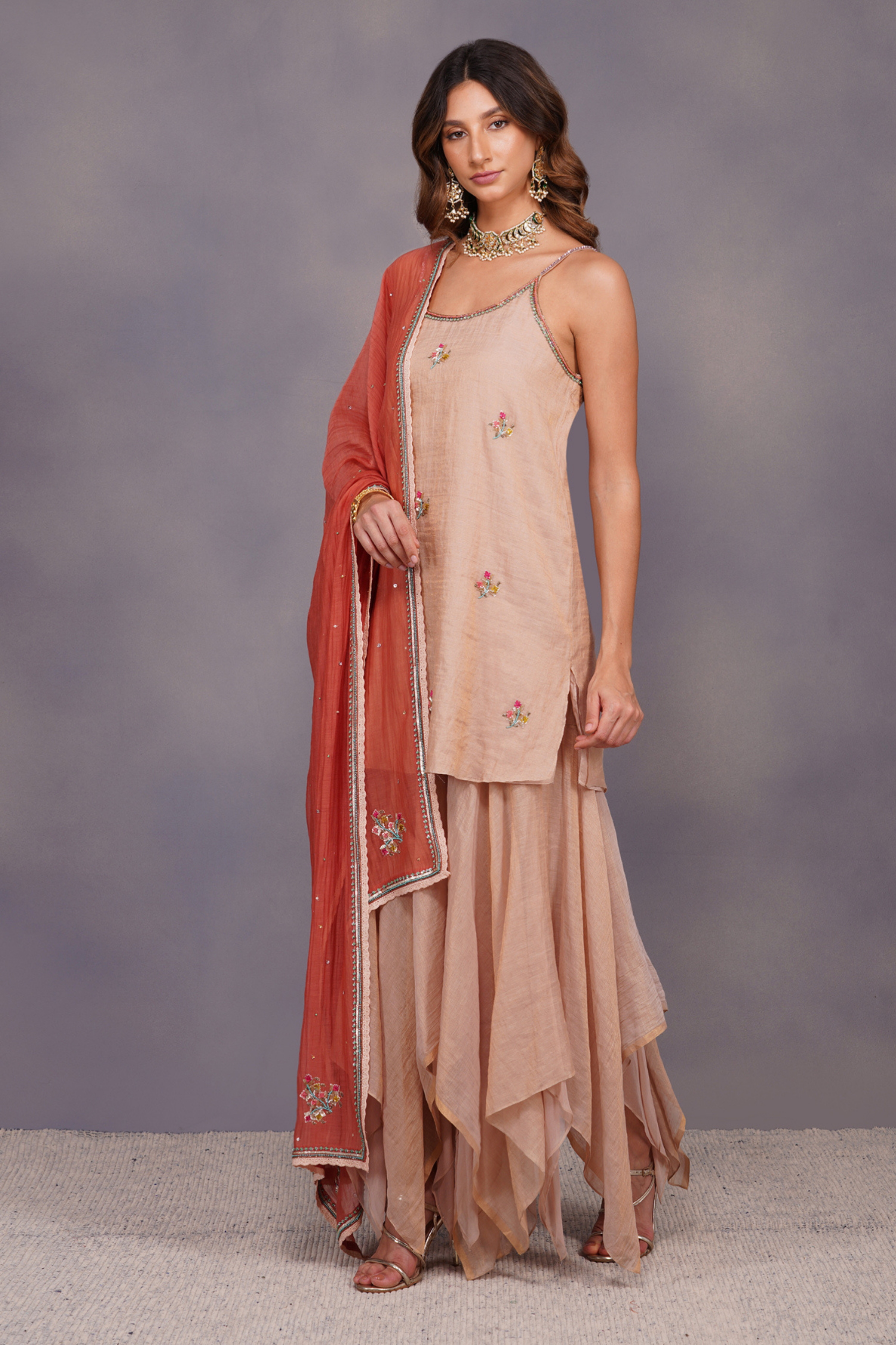 Spaghetti tissue kurta is adorned with multicolored sequins work. 